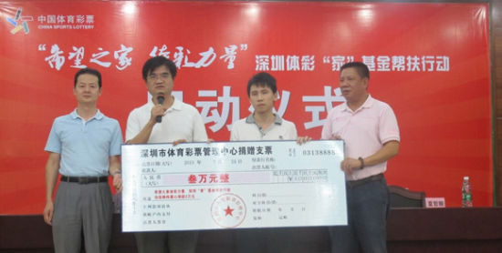 深圳市文体旅游局巡视员柯刚明（左二）和深圳市体彩中心主任夏哲顺（右一）代表深圳体彩人对张炳伟捐助3万元